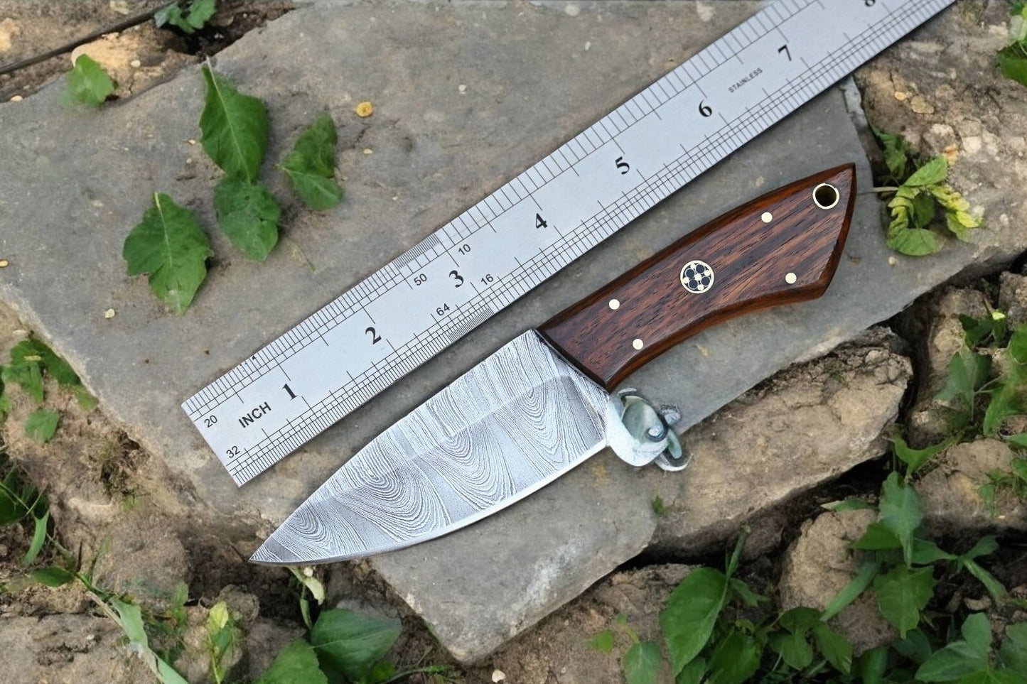 Damascus steel hunting knife in leather sheath, ready for outdoor adventures.