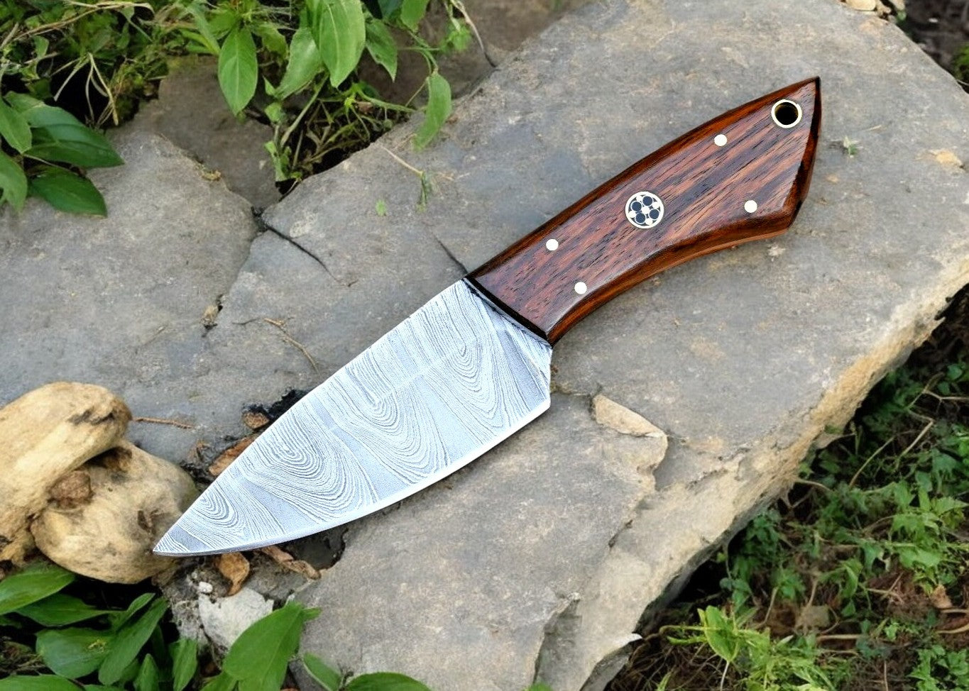 Ergonomic rosewood handle on a Damascus steel hunting knife for a comfortable grip.