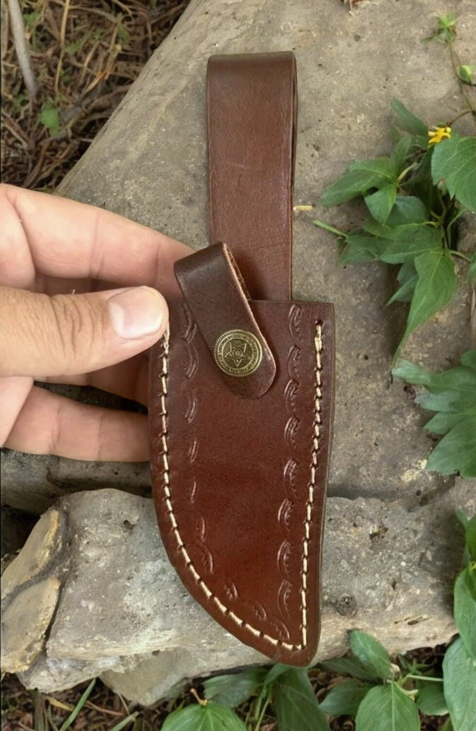 Leather sheath included with the handmade hunting knife, displayed alongside the knife.