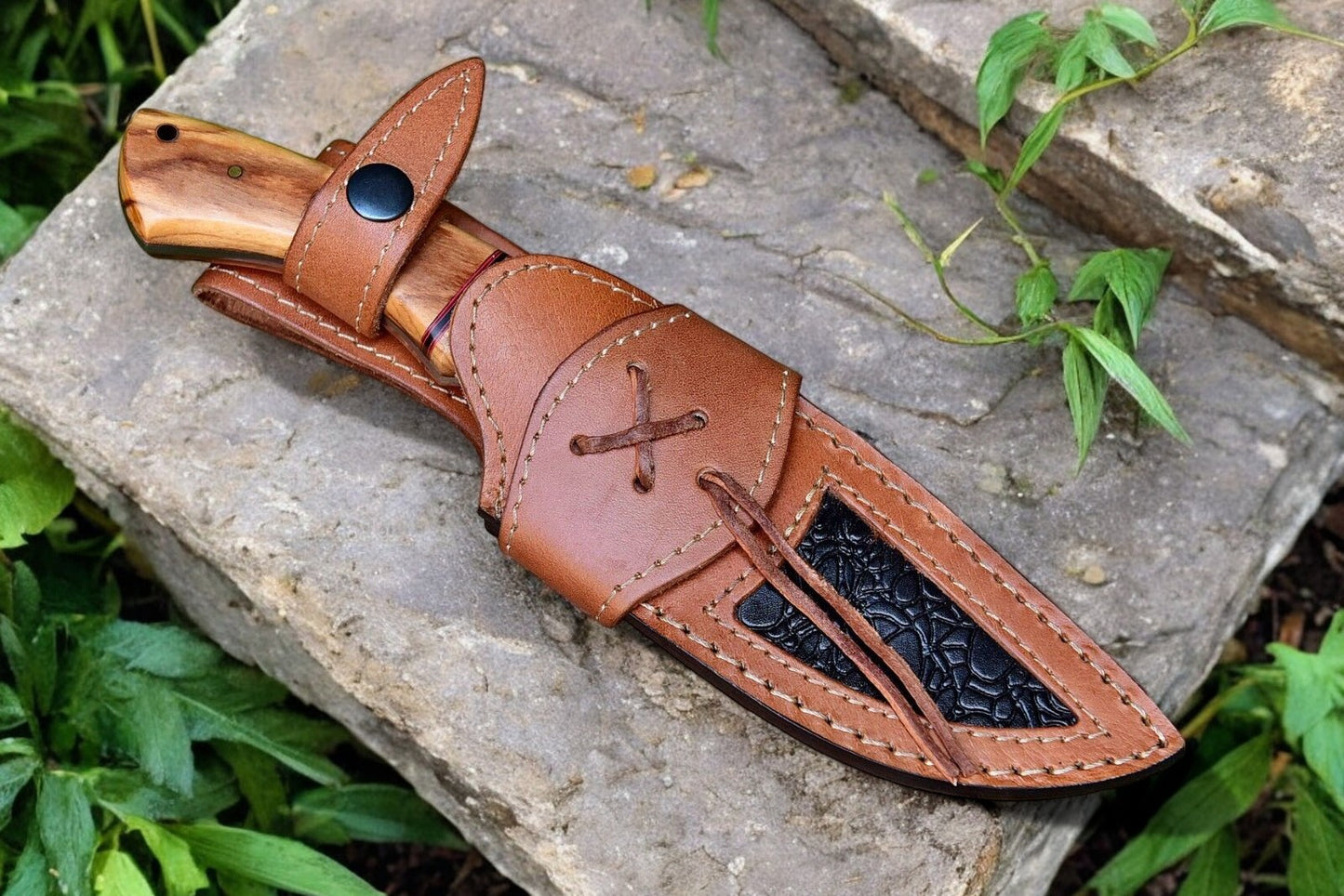 Leather sheath included with high end hunting knife, displayed alongside the knife.