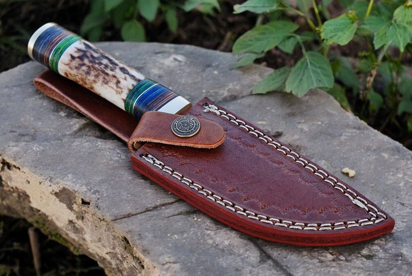 Detailed view of the brass guard and handle materials on a luxury hunting knife.