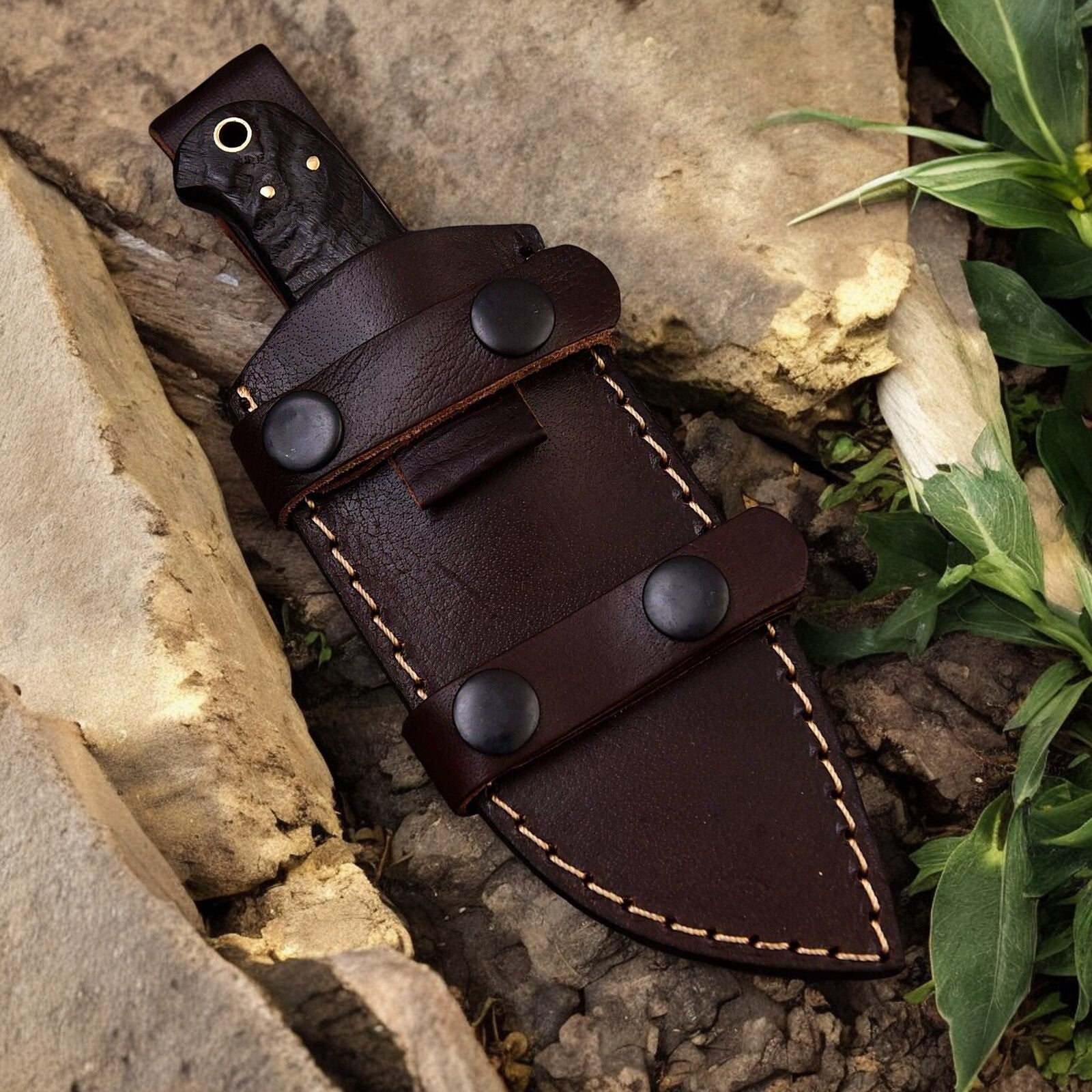 Leather sheath included with the hunt down knife, displayed alongside the knife.