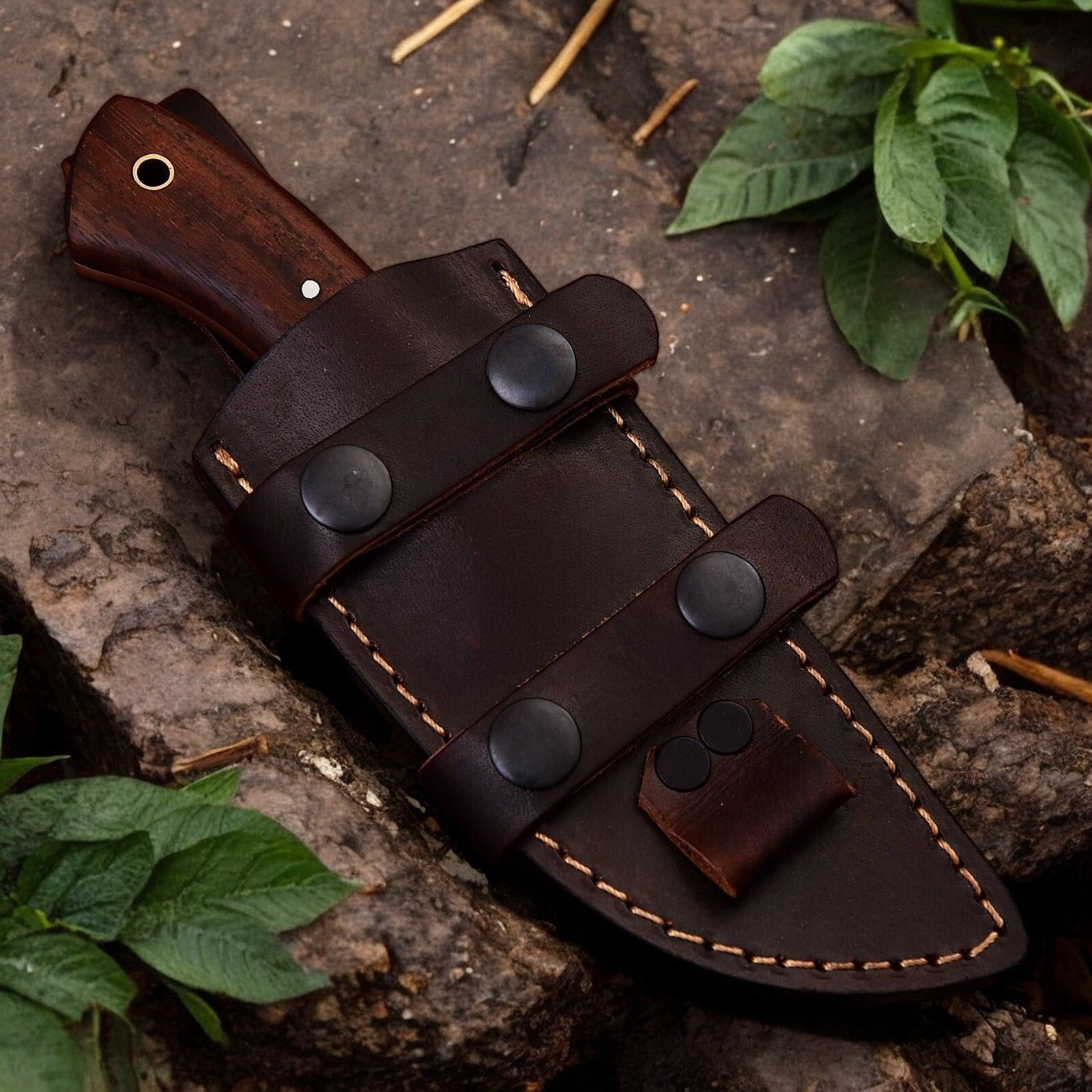 Leather sheath included with handmade hunting knife, displayed alongside the knife.