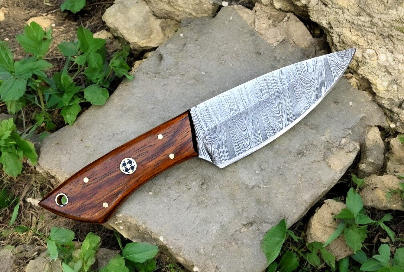 Full view of the Damascus steel hunting knife on a rustic wooden background.