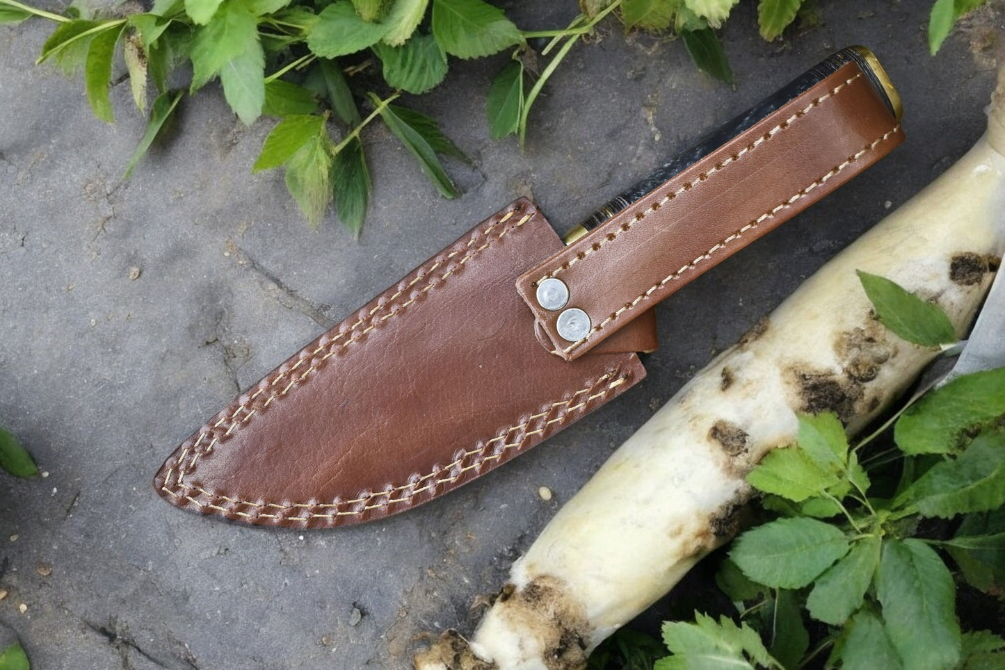 Custom hunting knife displayed on a natural background, showcasing its elegance and functionality.
