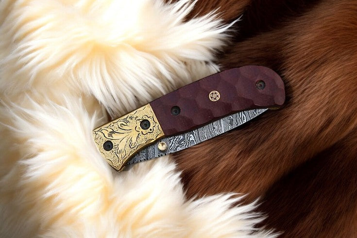 Damascus Steel pocket knife in leather case with engraved brass bolster detail
