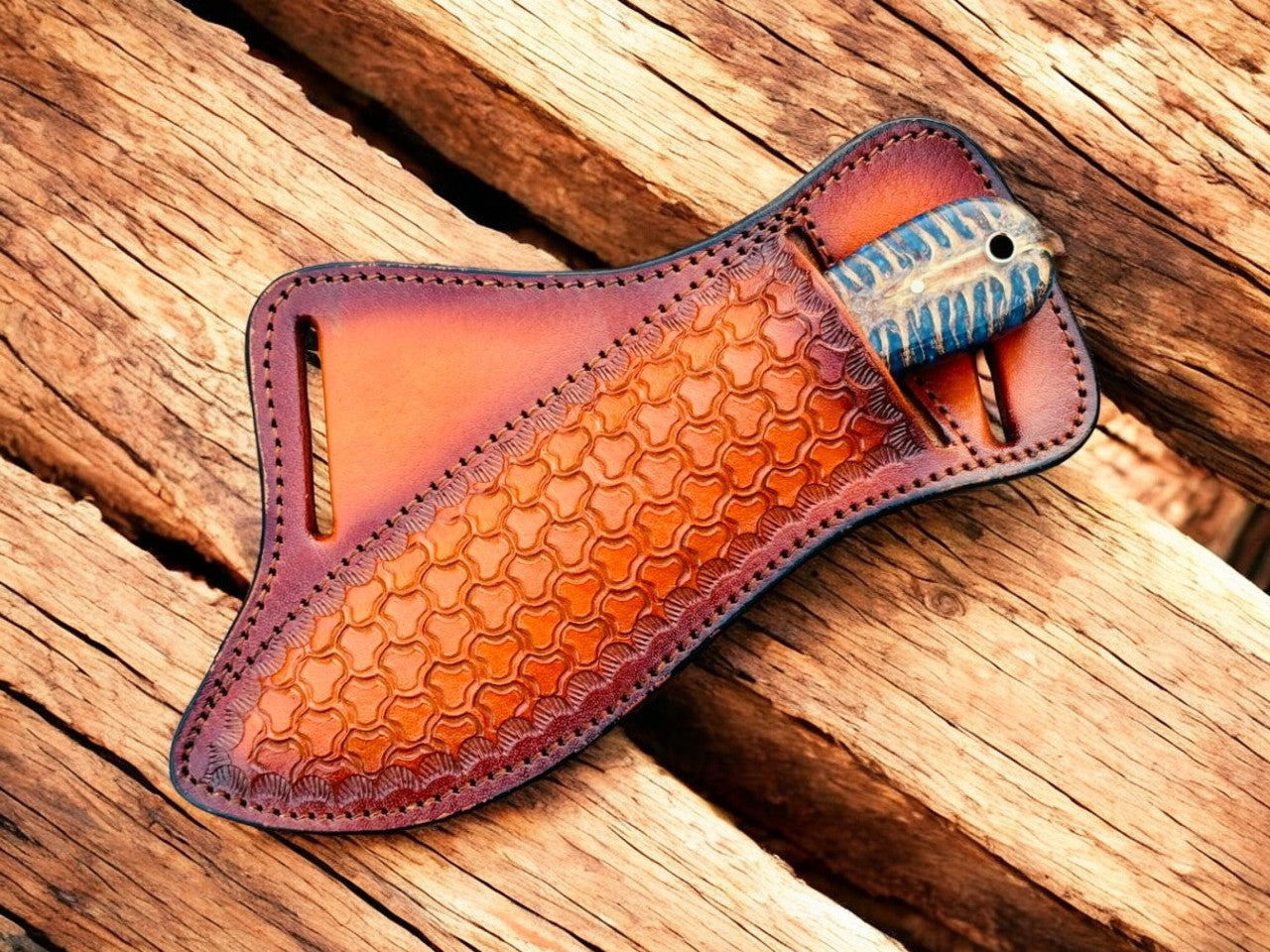 Brown leather sheath with textured surface on a wooden background