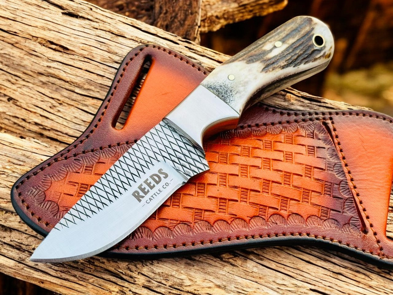 Knife with a leather sheath on a wooden surface, featuring the REEDS brand.