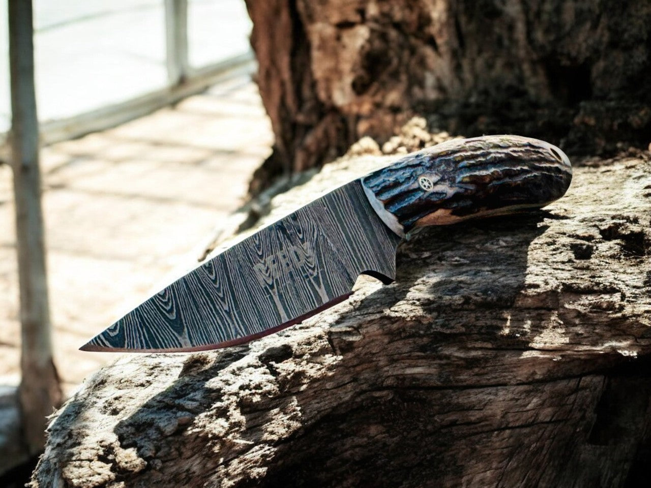 Decorative knife with a patterned blade on a wooden surface