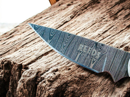 Damascus knife blade on a wooden surface