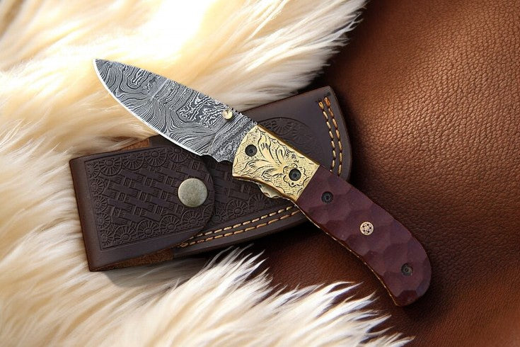 Damascus pocket knife with micarta handle and engraved bolster in leather case