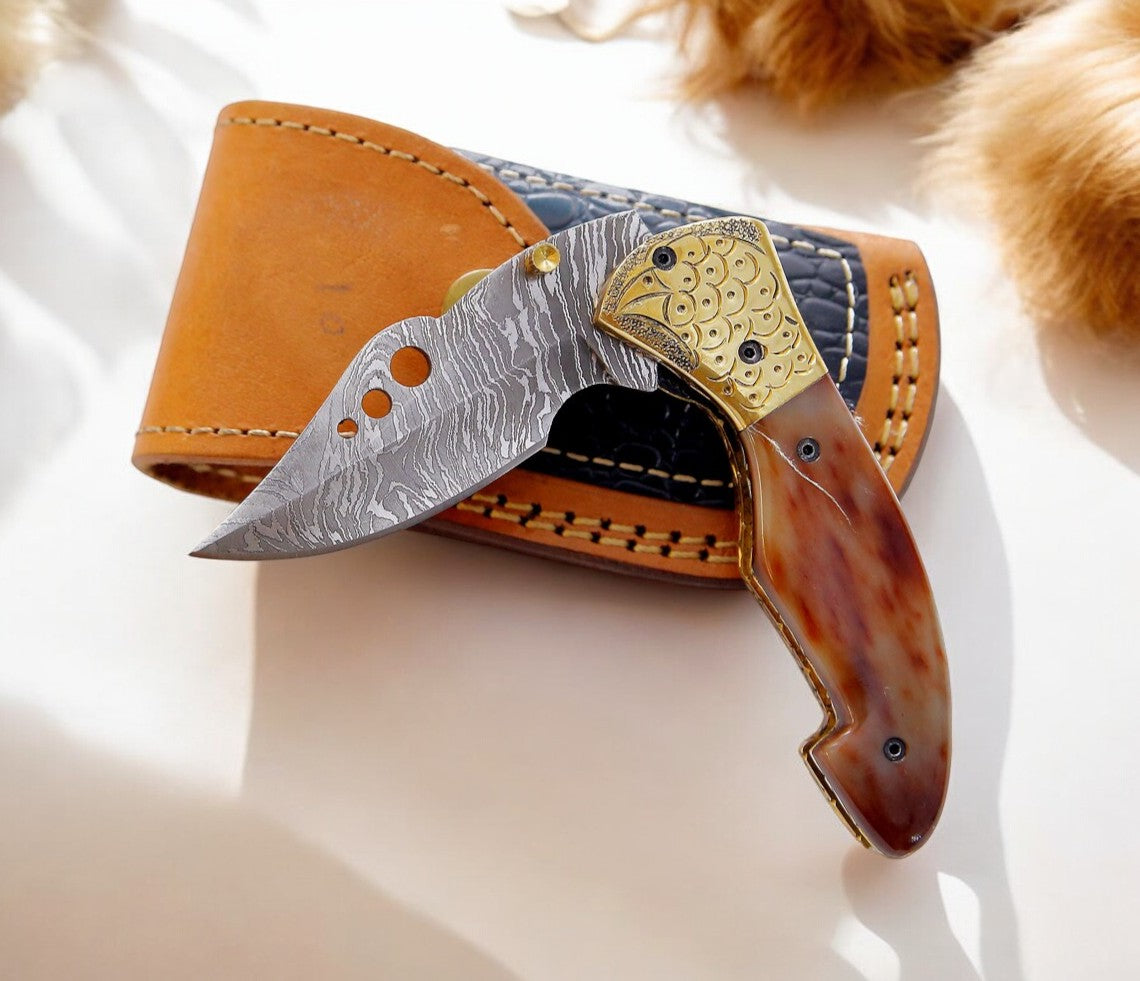 Engraved brass bolster on Damascus pocket knife with colored bone handle