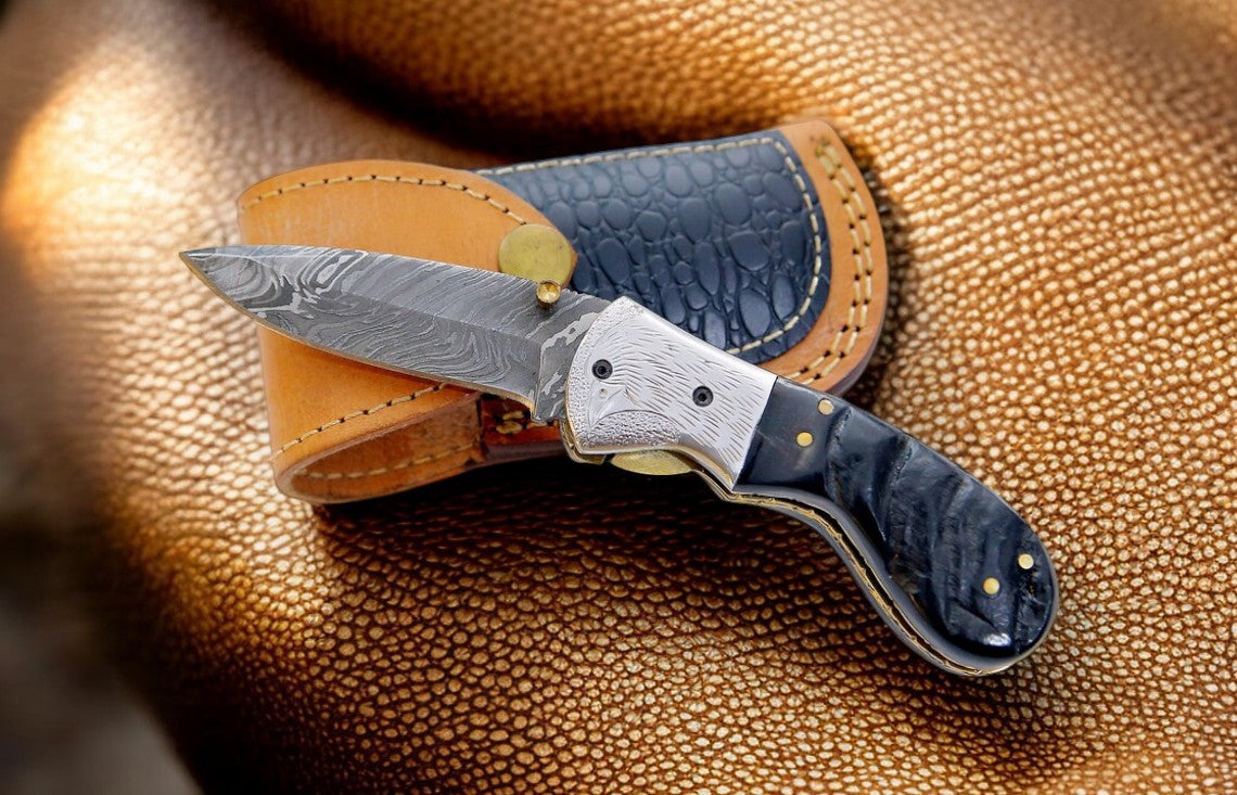 Close-up of Damascus steel blade on pocket knife with liner lock mechanism