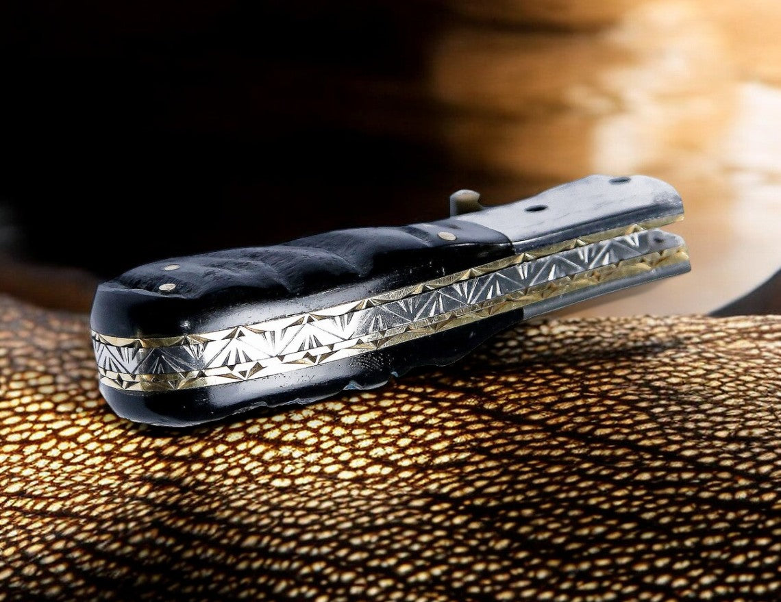 Sheep horn handle with engraved steel bolster on Damascus pocket knife