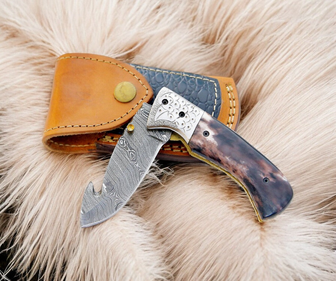 Damascus gut hook pocket knife with leather case and liner lock mechanism