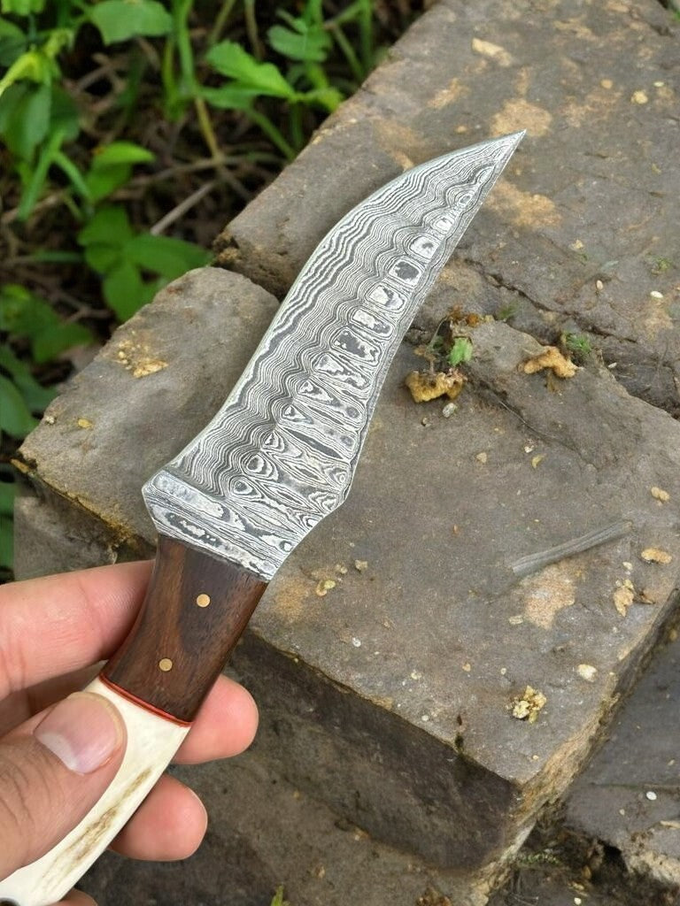 Damascus hunting knife in leather sheath, ready for outdoor adventures.
