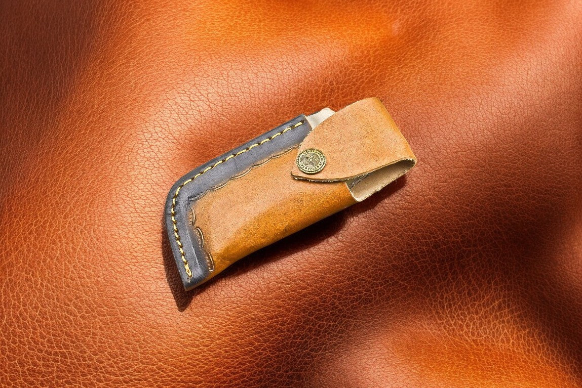 "Damascus pocket knife with leather case for storage and transport"
