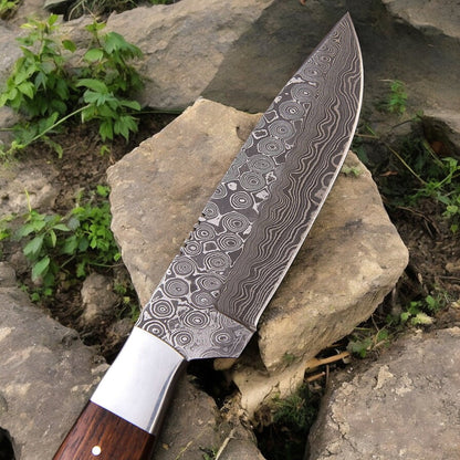 Close-up of the Damascus steel blade on the hunting knife, highlighting its sharpness.
