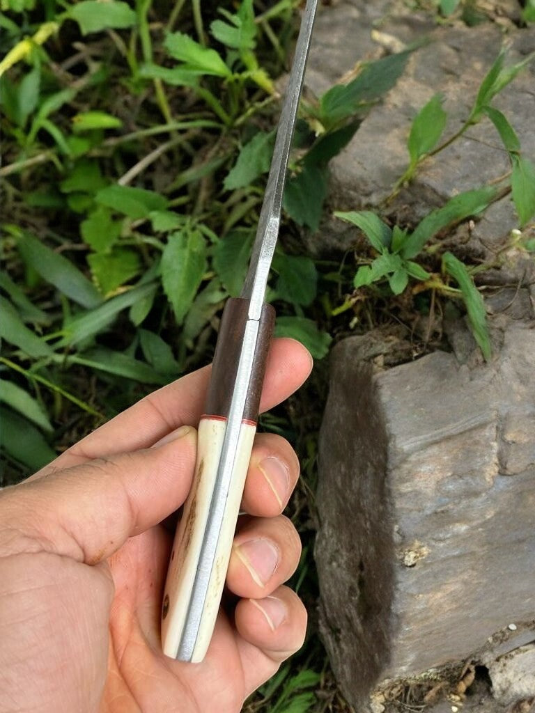 Close-up of the Damascus steel blade on a hunting knife, showcasing unique patterns.
