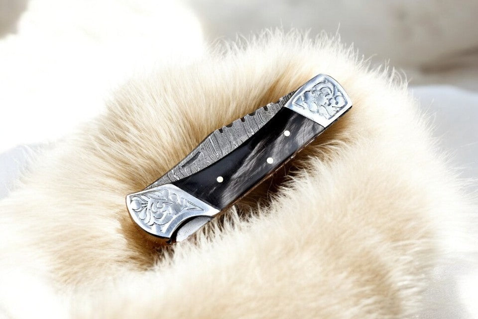 Close-up view of the buffalo horn handle with engraved steel bolster
