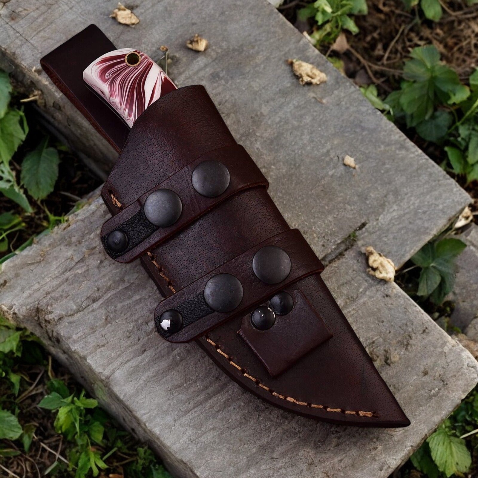 Leather sheath included with 7.5-inch steel hunting knife, displayed beside the knife.
