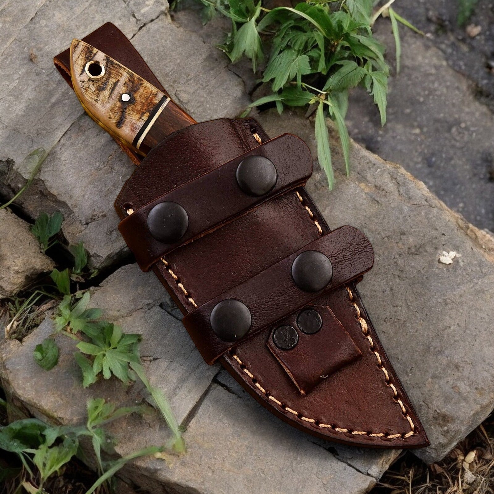 Leather sheath included with top hunting knife, displayed next to the knife.
